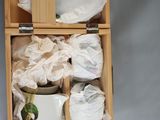 a wooden box with plates and bowls inside of it