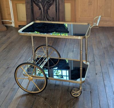 un chariot à boissons doré recouvert d'une serviette noire