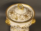 an image of a gold and white bowl with a lid on a table