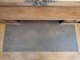 a wooden bench with a metal lion head on top of it