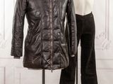 two mannequins in front of a white wall and a black jacket on a stand