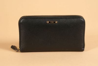 a black leather wallet with gold hardware and zipper closure
