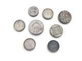six different types of silver coins on a white surface