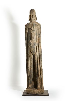 a wooden statue of a man with a helmet and cloak