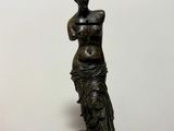 bronze statue of a woman holding a vase on a white background