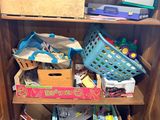 a wooden cabinet filled with lots of toys and books