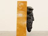 a statue of a man peeking out of a book