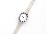 an image of a silver watch with blue crystals on a white background
