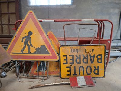 un tas de panneaux de chantier posés par terre dans une pièce