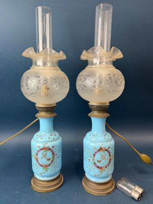 paire de lampes anciennes en verre bleu, ornées de finitions dorées, posées sur des socles en bois