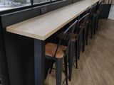 a long table with four stools in front of a window