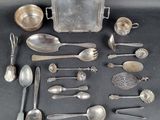 a lot of silver spoons and other silverware on a table