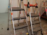 three ladders that are sitting in the middle of a room