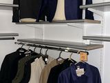 a closet with a lot of clothes hanging on the shelves
