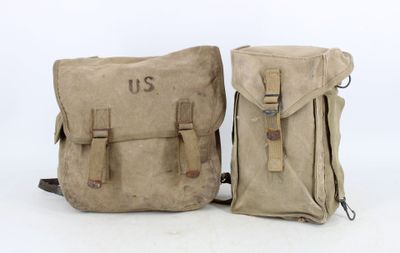 pair of wwii era canvas backpacks with leather straps