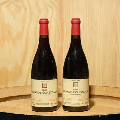 two bottles of wine sitting on top of a wooden barrel