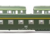 three green train cars sitting next to each other on a white surface