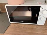 someone is taking a picture of a microwave on the counter