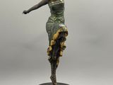 statue d'une femme en robe verte posée sur un socle noir