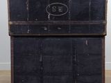 an old black trunk with a sign on it