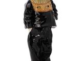 figurine of a man in a black suit and hat standing on a wooden base