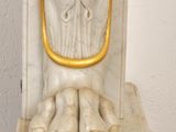 a statue of a man holding a clock on a pedestal