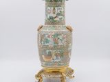 une image représentant un vase posé sur un socle doré, sur fond blanc