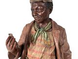 statue of a man with a hat and jacket holding a cigarette