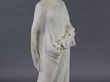 statue of a woman in a white dress with a bouquet in her hand