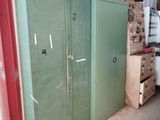 a large green cabinet in a garage with a lot of boxes