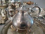 a silver tea pot sitting on a silver tray