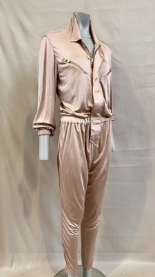 the mannequin is wearing a pink suit and pants on a stand