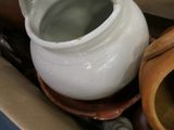 a white pitcher sitting on top of a brown bowl