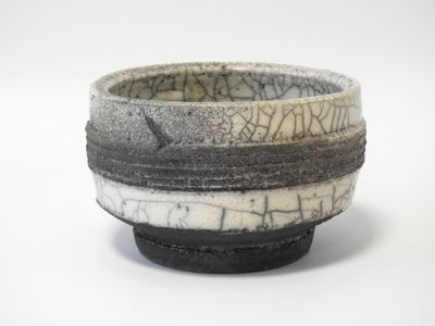un bol noir et blanc sur lequel figure une inscription