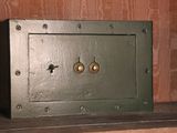 a small metal safe box on a shelf in a room