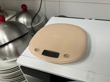 a kitchen scale on top of a stack of dishes