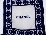 a white plate topped with a blue and white chanel scarf