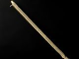 a close up of a gold bracelet on a black background
