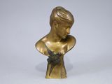 bronze bust of a young boy with a bow on his chest