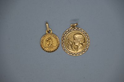 deux pendentifs en forme de pièces d'or représentant le portrait d'un homme et d'une femme