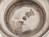 a silver bowl with a silver object in it
