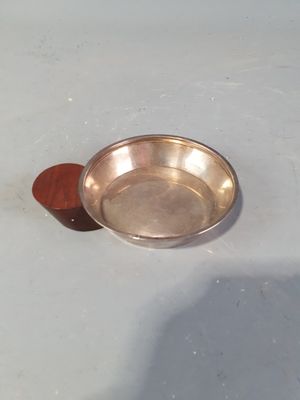 un petit bol en métal contenant une cuillère en bois