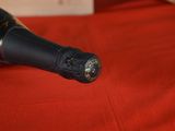 a bottle of wine sitting on a red table cloth