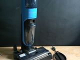 a blue and black vacuum sitting on a wooden table