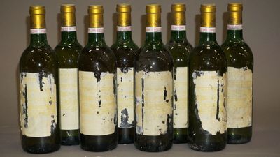 six bouteilles de vin sont alignées sur une table