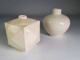 deux vases blancs posés l'un à côté de l'autre sur une table