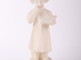 une statue blanche représentant une jeune fille tenant une fleur dans ses mains
