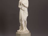 a white statue of a woman holding a child on top of a pedestal