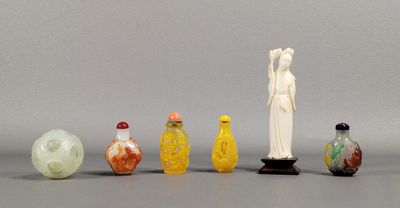 plusieurs vases en verre et une statue représentant une femme, posés sur une table