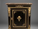 une armoire peinte en noir et or, ornée d'une tête de lion sur la porte